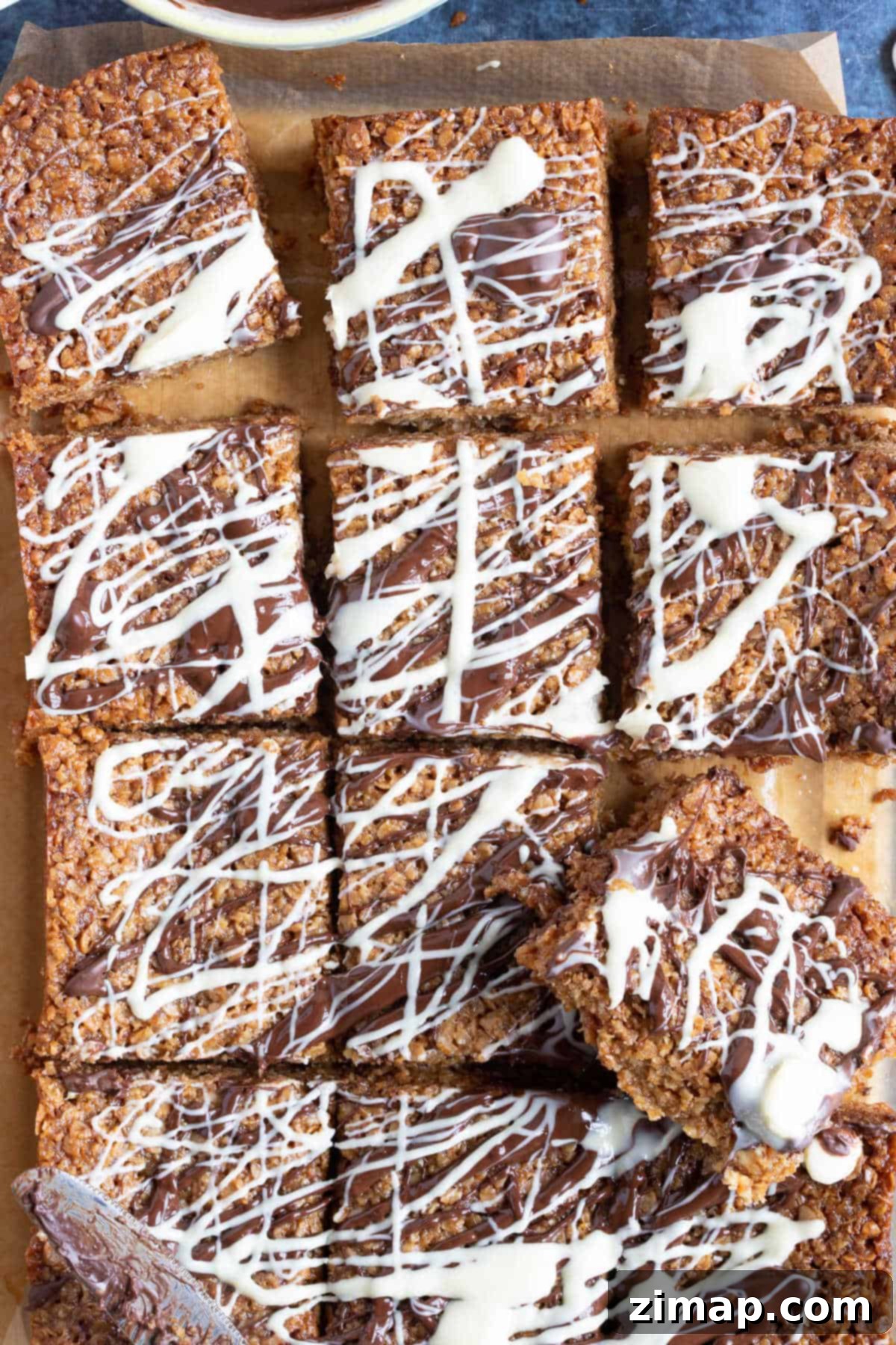 Εύκολες Μπάρες Βρώμης με Τσιπς Σοκολάτας 2 Flapjacks με κομματάκια σοκολάτας και λιωμένη σοκολάτα από πάνω.