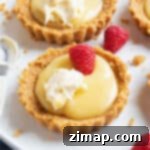 Μικρά Ταρτάκια Λεμονοκρέμας 6 Μια λεμονοτάρτα γαρνιρισμένη με σμέουρα και κρέμα.