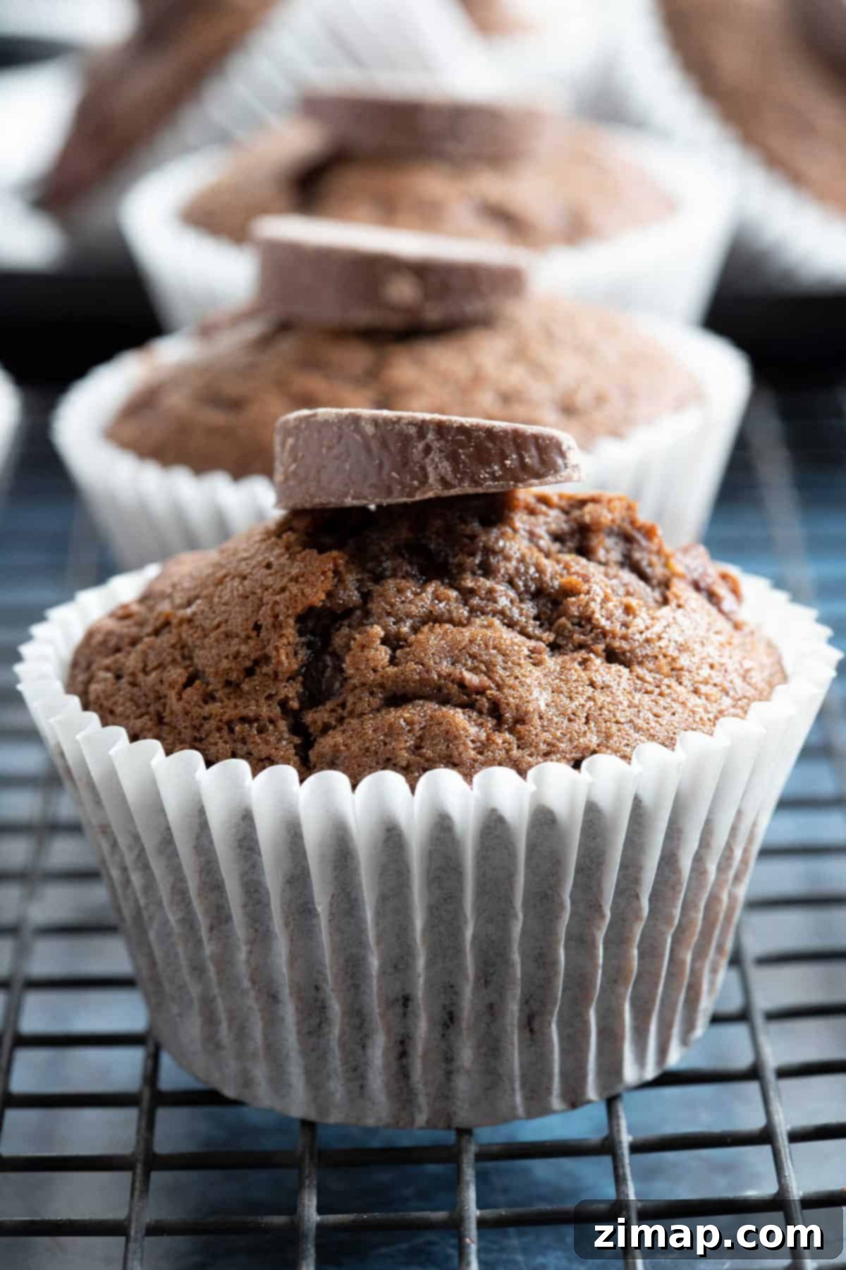 Εύκολα Μάφινς Σοκολατοπορτοκαλένια 7 A chocolate orange muffin in a white paper case.