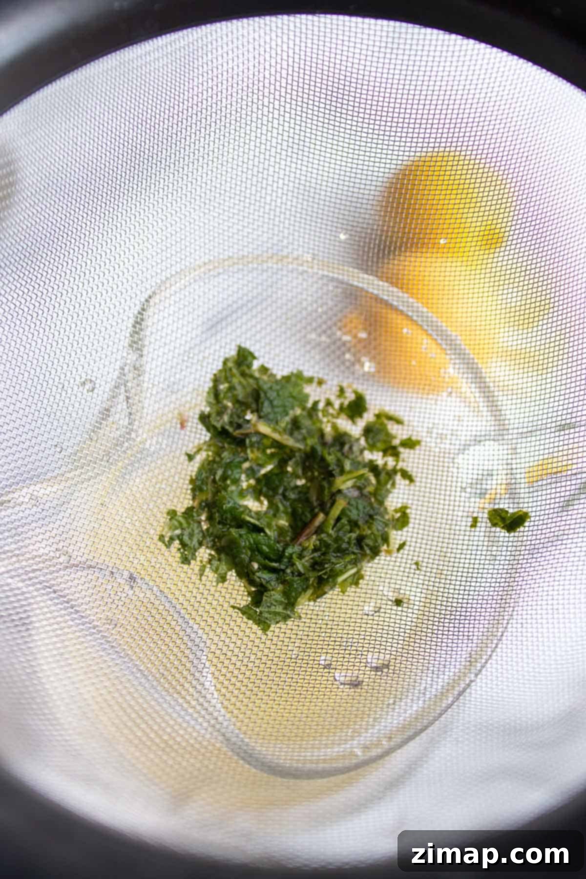 Δροσερή Λεμονάδα Μέντας 6 Ο δυόσμος σουρώνεται από ένα λεπτό σουρωτήρι.